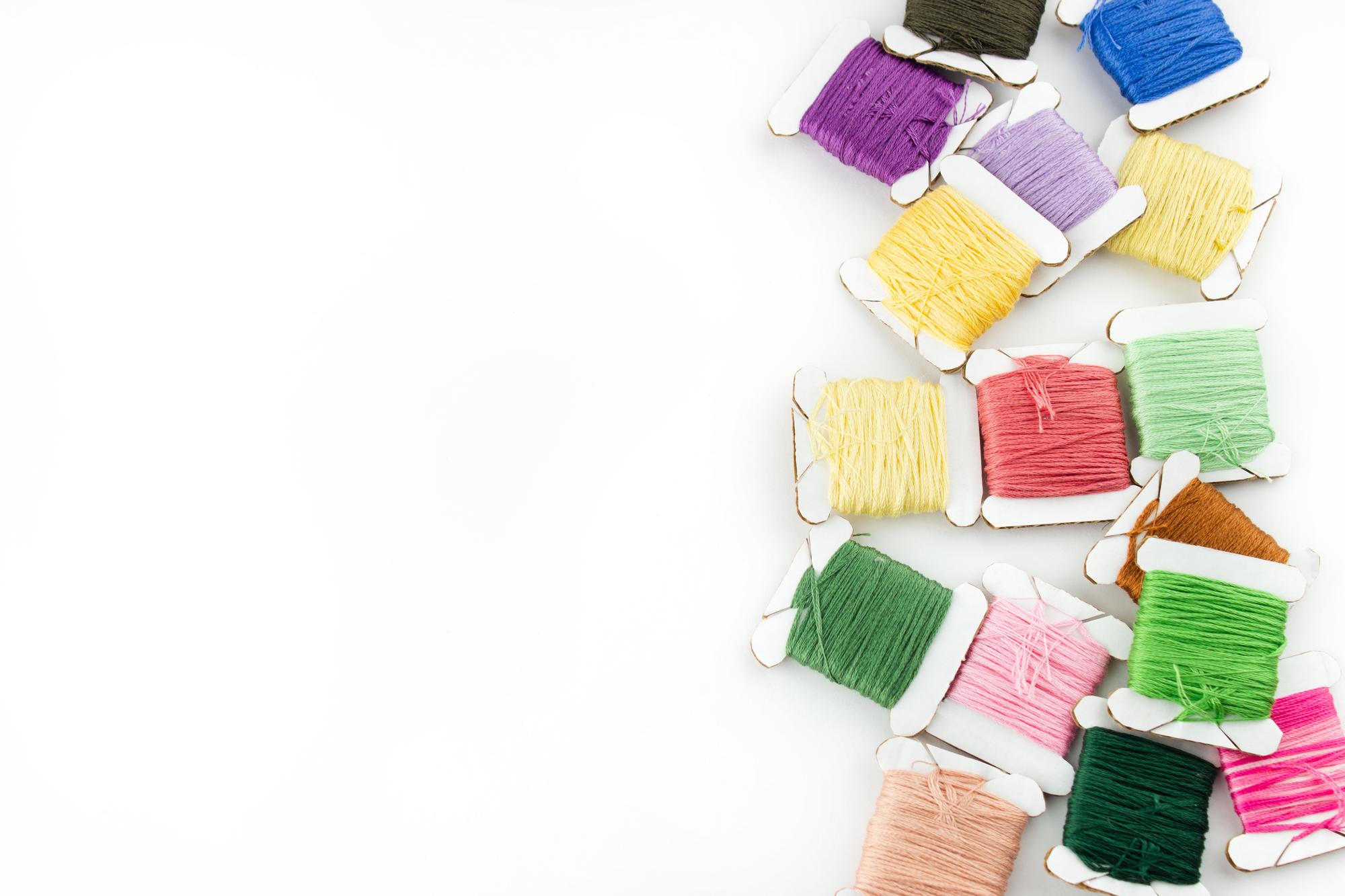 Array of colorful threads and hand-stitched sampler